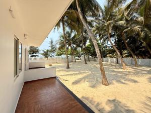 a house on the beach with palm trees at Dariya Sea Front by Beach County in Udupi