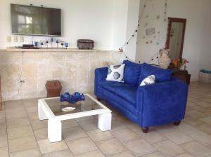 een woonkamer met een blauwe bank en een salontafel bij Los Balcones A1 in Sosúa