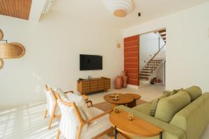 a living room with a couch and chairs and a tv at ELIVAAS Mirai Leo - 3 BHK Villa Near Vagator Beach With Pool in Vagator +56 photos