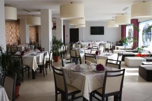 a dining room with white tables and chairs at Hotel Cliché in San Lucido