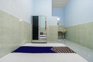 a bathroom with a shower with a blue and white rug at SPOT ON 93965 Ibrahim Guest House Syariah in Kediri