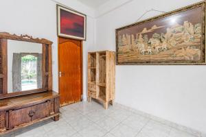 a room with a large painting on the wall and a mirror at Belvilla Ratna Resort Ubud PalaceNearUbud Palace in Ubud
