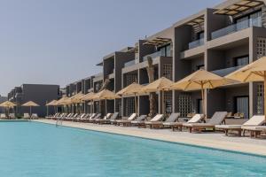 a resort with a swimming pool with chairs and umbrellas at Aldiana Club Naga Bay in Hurghada