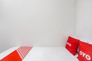 a white room with red pillows on a bed at OYO Life 93977 Suterejo Homestay Syariah in Surabaya