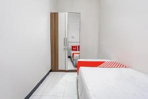 a bedroom with a bed and a door to a bathroom at OYO Life 93977 Suterejo Homestay Syariah in Surabaya +20 photos