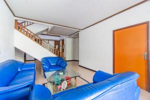- un salon avec des chaises bleues et un escalier dans l'établissement OYO Life 93978 Wisma Homestay Syariah, à Surabaya