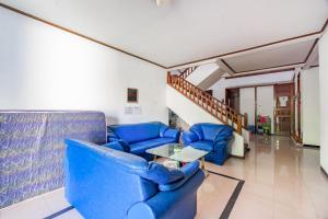 un salon avec des canapés bleus et une table dans l'établissement OYO Life 93978 Wisma Homestay Syariah, à Surabaya