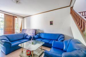 un salon avec des canapés bleus et une table dans l'établissement OYO Life 93978 Wisma Homestay Syariah, à Surabaya