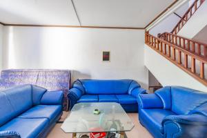un salon avec des canapés bleus et une table dans l'établissement OYO Life 93978 Wisma Homestay Syariah, à Surabaya