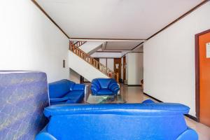 une chambre avec des chaises bleues et un escalier dans l'établissement OYO Life 93978 Wisma Homestay Syariah, à Surabaya 25 autres photos