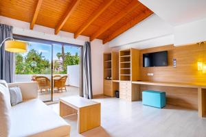 a living room with a couch and a tv at Bahía de Alcudia Hotel & Spa in Port d'Alcudia