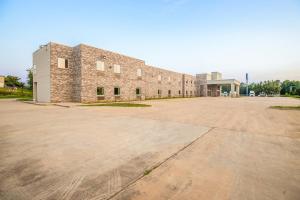 a large brick building with a large parking lot at OYO Hotel Adairsville Calhoun South I-75 in Adairsville