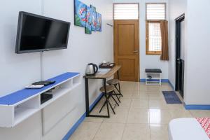 un soggiorno con una TV a parete di OYO 93995 Griya Va Syariah a Serang