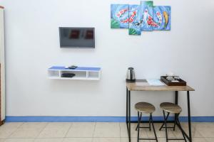 un tavolo con due sgabelli e una TV a muro di OYO 93995 Griya Va Syariah a Serang Altre 24 foto