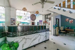 Un vestíbulo de un restaurante con un mostrador y una mesa. en Hotel O Sidoarjo Near Juanda International Airport, en Sidoarjo