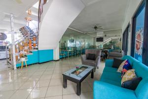 Una sala de estar con sofás azules y una mesa. en Hotel O Sidoarjo Near Juanda International Airport, en Sidoarjo 29 fotos más