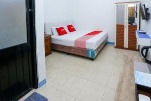 una camera da letto con un letto con cuscini rossi di OYO 93995 Griya Va Syariah a Serang