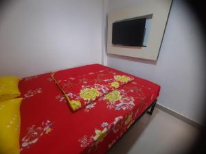 a red bed in a room with a tv at Hotel O Jm Guest House 2NearStasiun karawang in Pundong