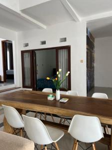 a dining room with a wooden table and white chairs at Villa Dua Kota - Dekat Malang dan Batu - 10 menit - MURAH RAME-RAME in Dau