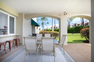 a dining room with a table and chairs on a patio at Wailea Hidden Gem in Wailea