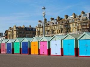 a row of colorful beach huts in front of a building at Albany, Brighton & Hove in Brighton & Hove