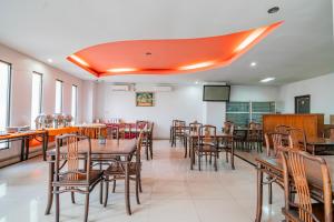 a dining room with wooden tables and chairs at Collection O Pusat Kota Pekanbaru Near Mall Ska Formerly Hotel Olgaria in Pekanbaru +45 photos