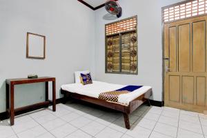 a bedroom with a bed and a window and a door at Hotel O Agung in Purwokerto