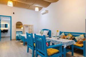 a dining room with blue chairs and a table at Thuy Tien Mui Ne Homestay BBQ Free in Mui Ne