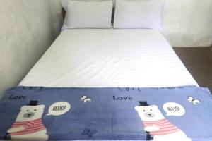 a bed with two polar bears on a blue blanket at Hotel O Homestay Banyumili Samigaluh in Semigaluh