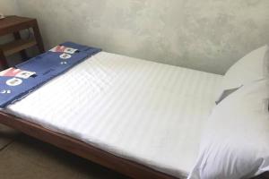 a bed with a blue ribbon on top of it at Hotel O Homestay Banyumili Samigaluh in Semigaluh +17 photos