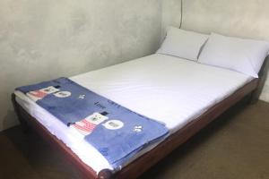 a bed with a blanket on top of it at Hotel O Homestay Banyumili Samigaluh in Semigaluh