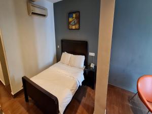 a small bedroom with a bed and a chair at Hotel O Crossroads Hotel in Kuala Lumpur