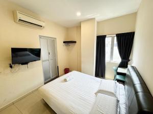 a hotel room with a bed and a flat screen tv at Hotel O Furich Hotel in Mentekab