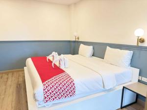 a bed with a red and white blanket on it at Collection O The Singha Chiangmai Hotel in Chiang Mai