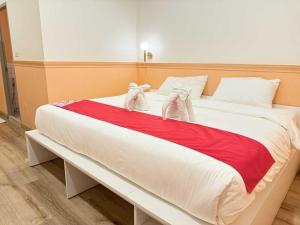 a large bed with two stuffed animals on it at Collection O The Singha Chiangmai Hotel in Chiang Mai +104 photos