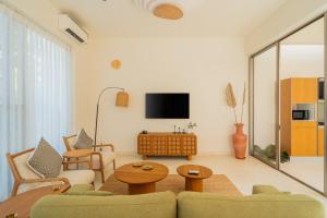 a living room with a couch and a tv at ELIVAAS Mirai Aries 3 BHK Retreat With Private Pool Near Famous Beaches in Vagator +43 photos