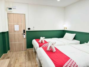 two beds in a room with two stuffed animals on them at Collection O The Singha Chiangmai Hotel in Chiang Mai
