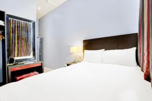 a bedroom with a large bed and a window at London Shelton Hotel, Finsbury Park in London