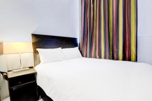 a hotel room with a bed and a curtain at London Shelton Hotel, Finsbury Park in London +39 photos
