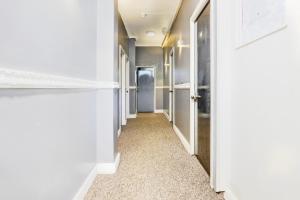 伦敦London Shelton Hotel, Finsbury Park的一条带白色墙壁和门的走廊