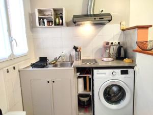 a kitchen with a sink and a washing machine at Le Petit Studio in Gap