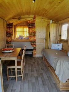 a bedroom with a bed and a desk and a table at Le nid des crinières vagabondes in Oletta