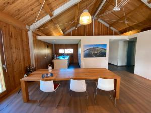 a dining room with a wooden table and white chairs at Ferienhaus Sonnenchalet in Bodman-Ludwigshafen