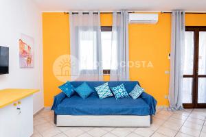 a living room with a couch with blue pillows at Alice Flat - SAN FOCA in San Foca