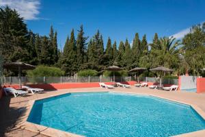 滨海阿热莱斯Camping maeva Escapades Les Abricotiers的配有椅子和遮阳伞的游泳池
