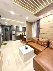 a living room with a couch and a table at The Prim Grand Condo Wongamat N103 - Spacious apartment near the sea in Pattaya North