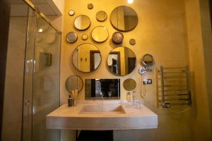a bathroom with a sink and mirrors on the wall at Hotel Boutique Patio del Posadero in Córdoba