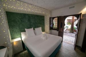 a bedroom with a large white bed with lights on the wall at Hotel Boutique Patio del Posadero in Córdoba