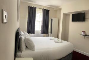 a bedroom with a large white bed with a window at Oban Victoria Hotel in London