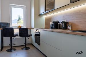 una cucina con due sedie e un piano di lavoro di MoHost Noua 3 - Premium Escape with Balcony Views a Braşov